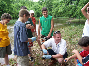 Chris Riggert with a group of boys performing water quality monitoring.